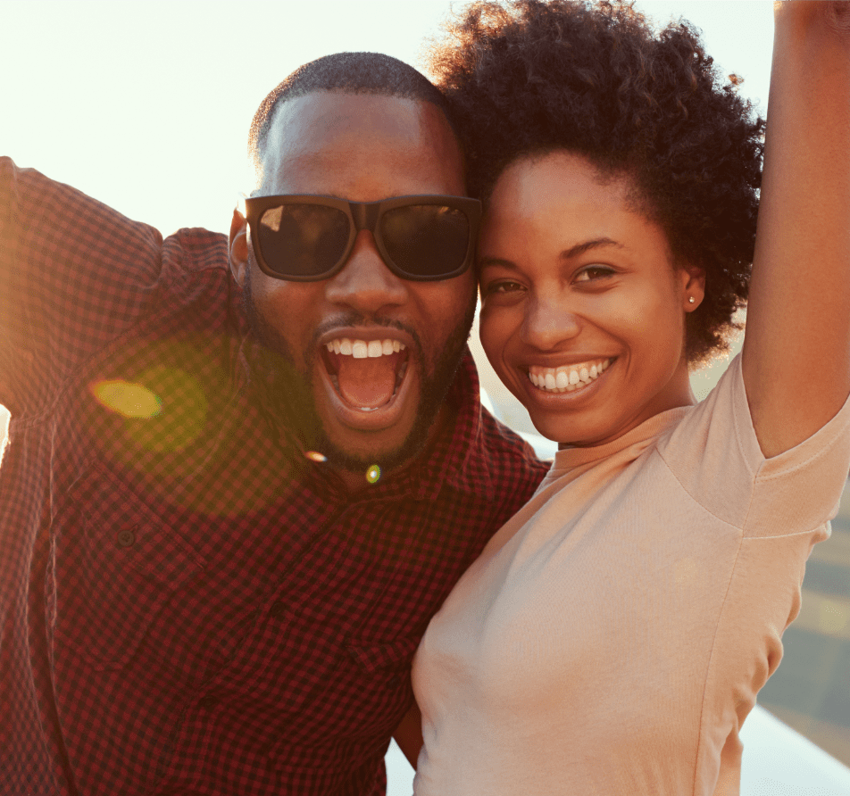 An adult couple smiling outdoors