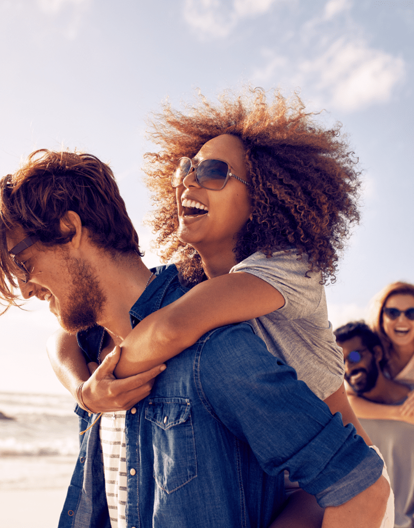 Teens outside at the beach wearing sunglasses.