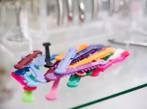 Glass table with multicolored orthodontic ligatures for braces.