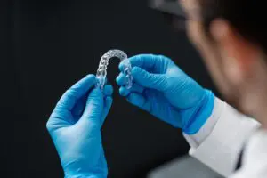 Invisible orthodontics cosmetic aligners in hands of doctor