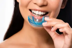 cropped view of woman using mouth guard isolated on white