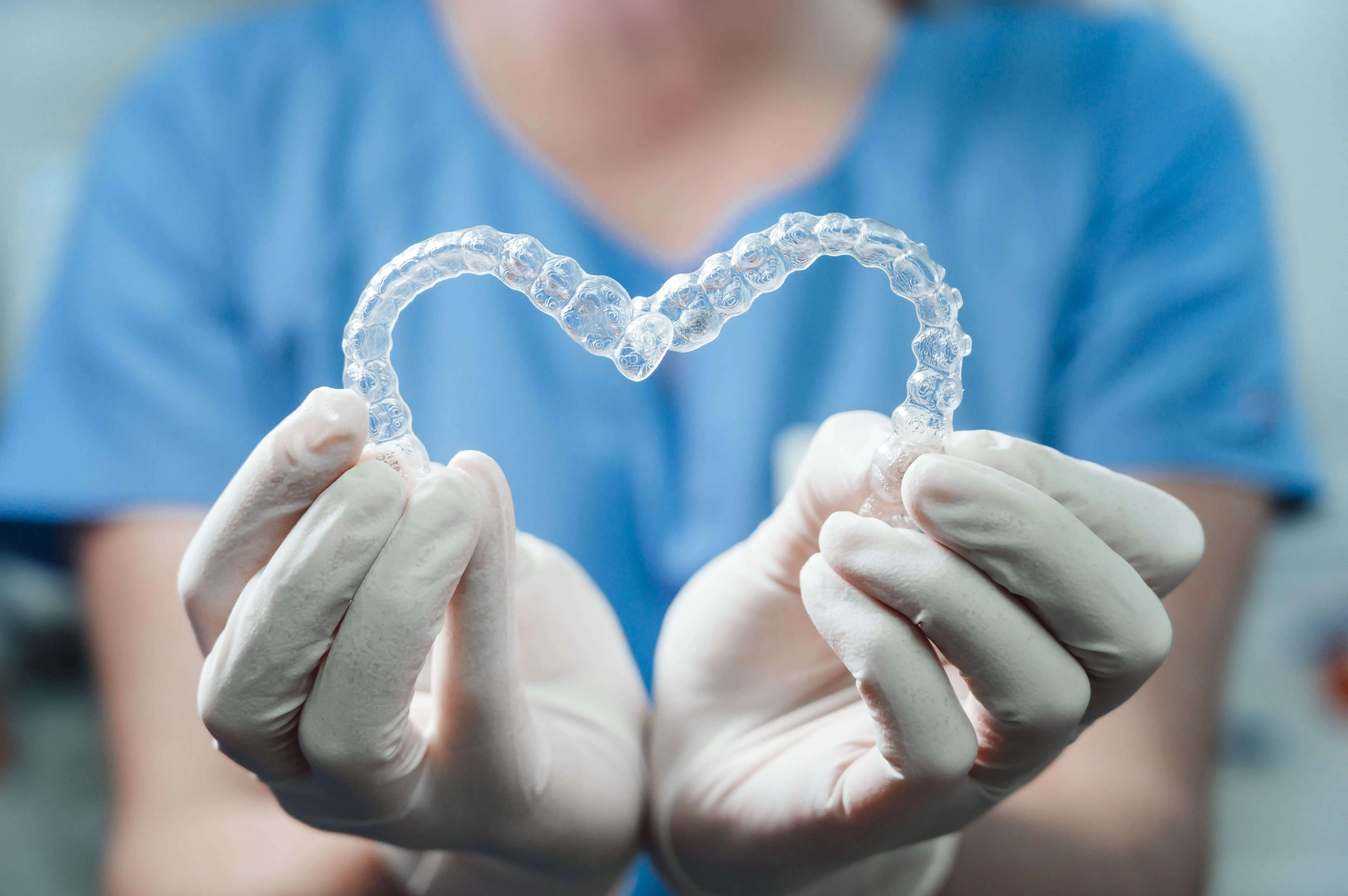 doctor holding 2 heart shaped aligners