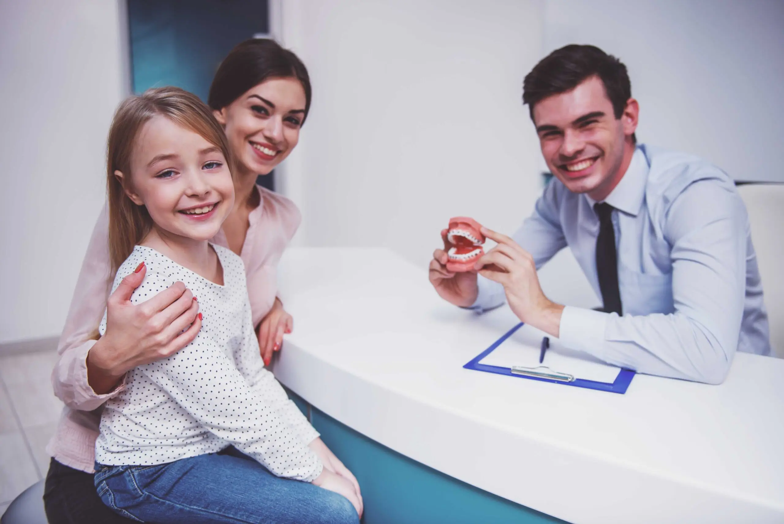 mother and daughter consulting with a dentist