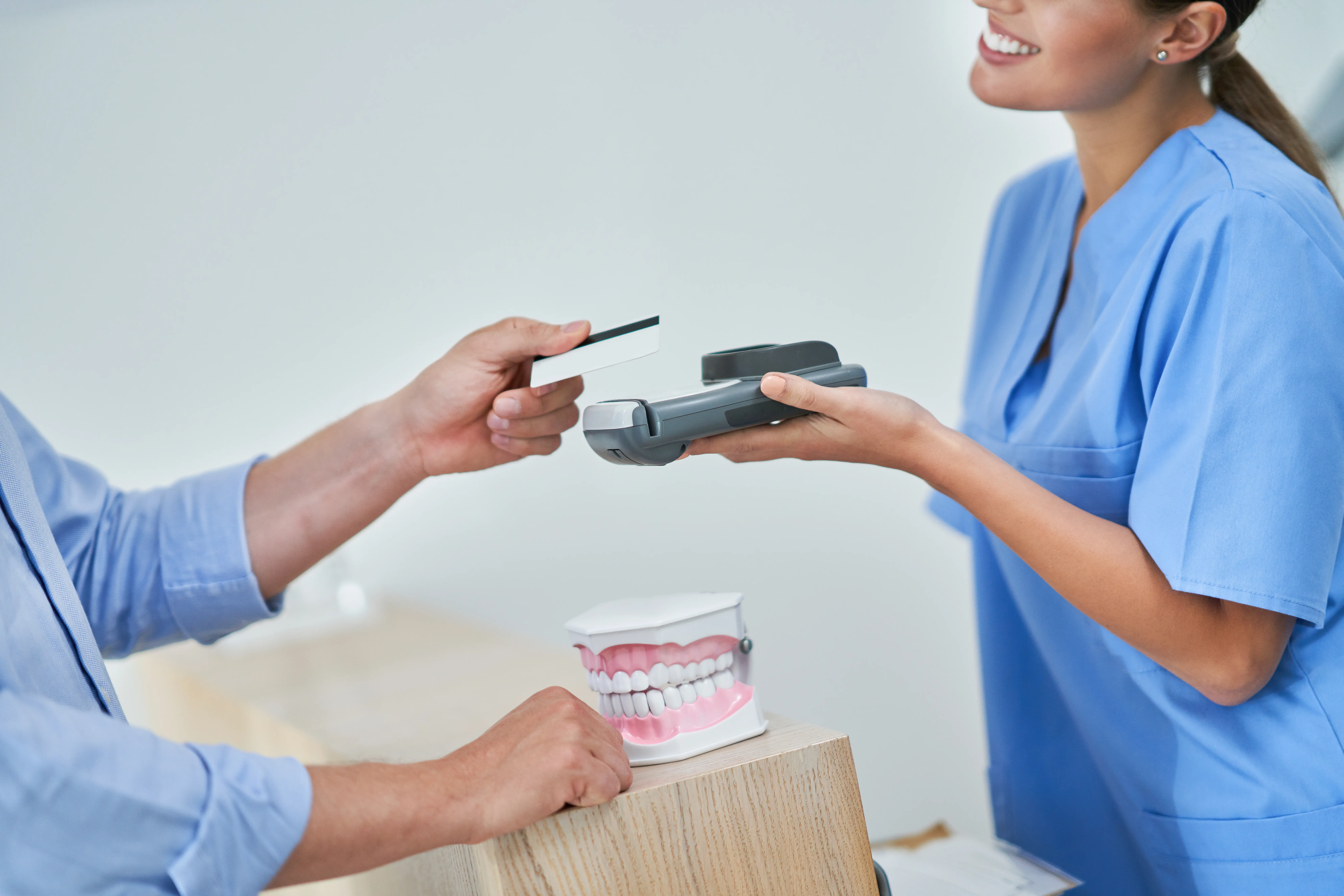 Picture of male patient paying for dental visit in clinic