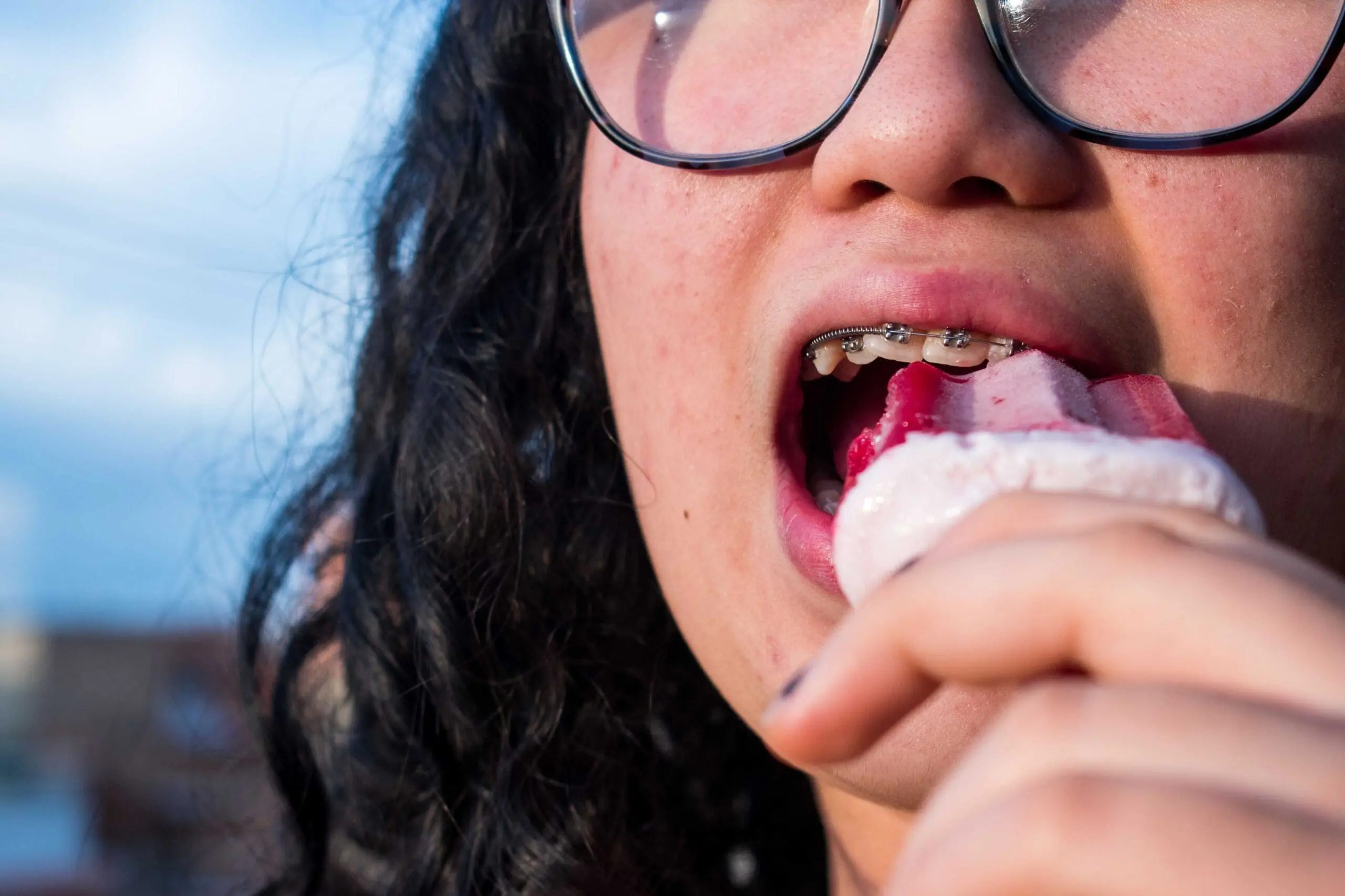 woman with metal braces enjoying her ice cream