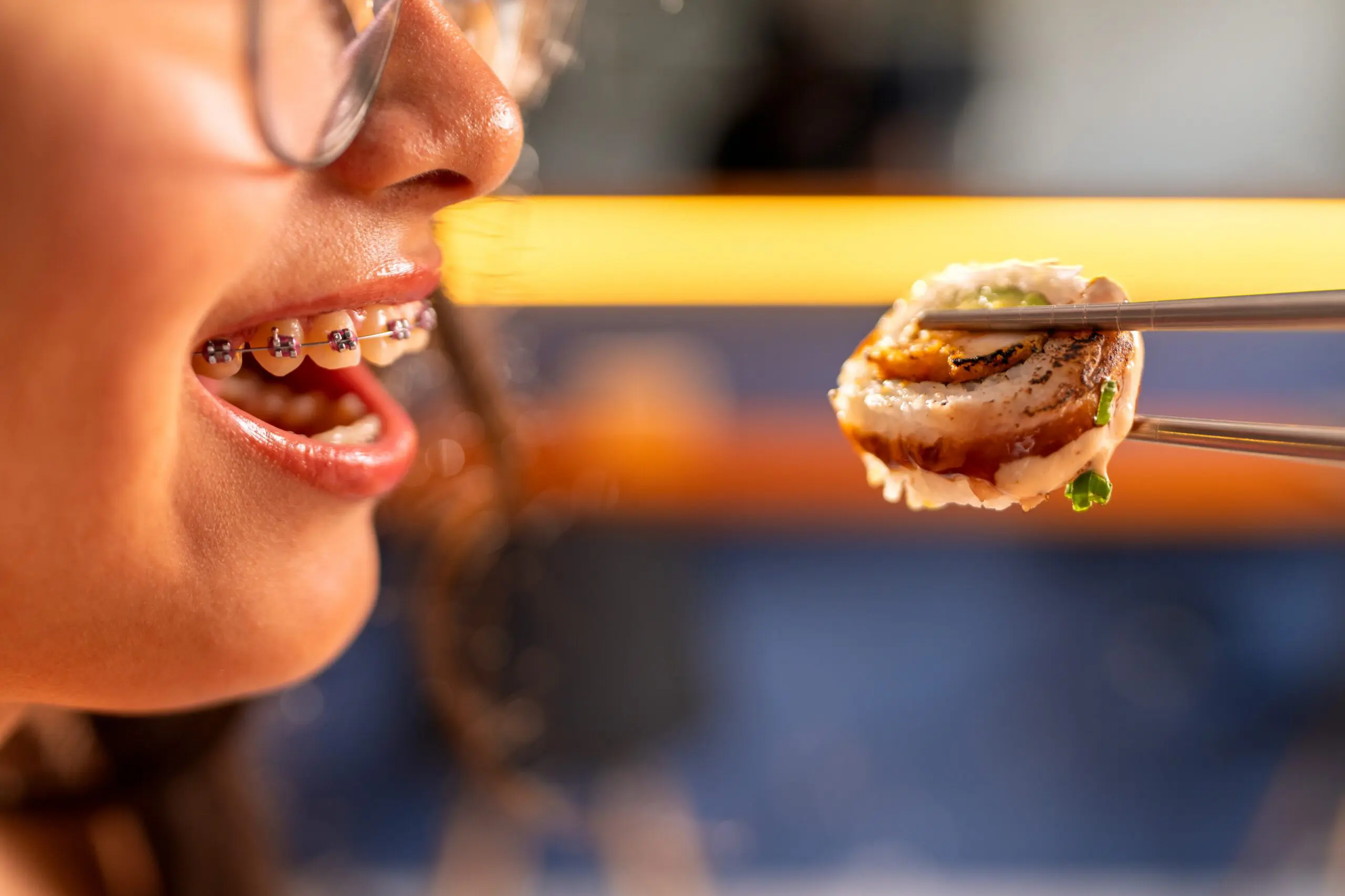 woman with braces enjoying sushi
