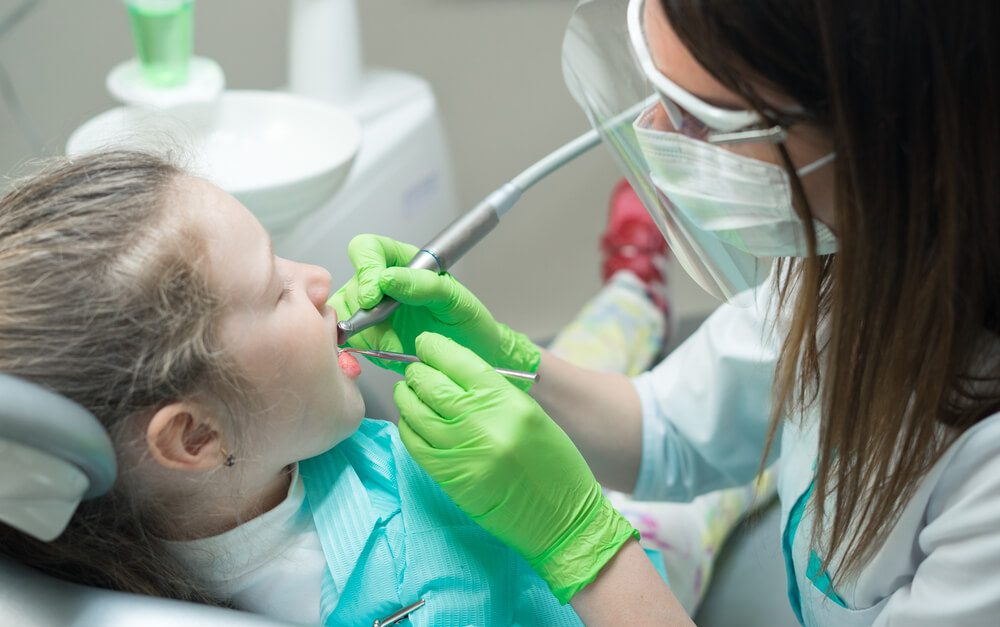 Dentist treating childs teeth - Smile Bliss