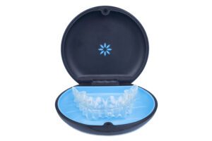 Isolated container with transparent invisalign aligner retainers or removable braces on white background