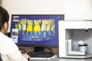 Person working on computer with dental software platform for mak