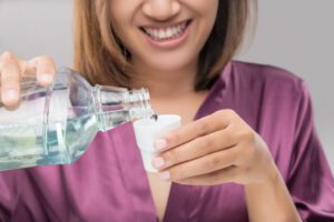 Woman Using Mouthwash After Brushing, Portrait Hands Pouring Mo