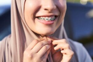 A woman with braces on her teeth is smiling
