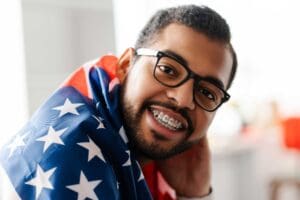 young man smiling with braces and eyeglasses