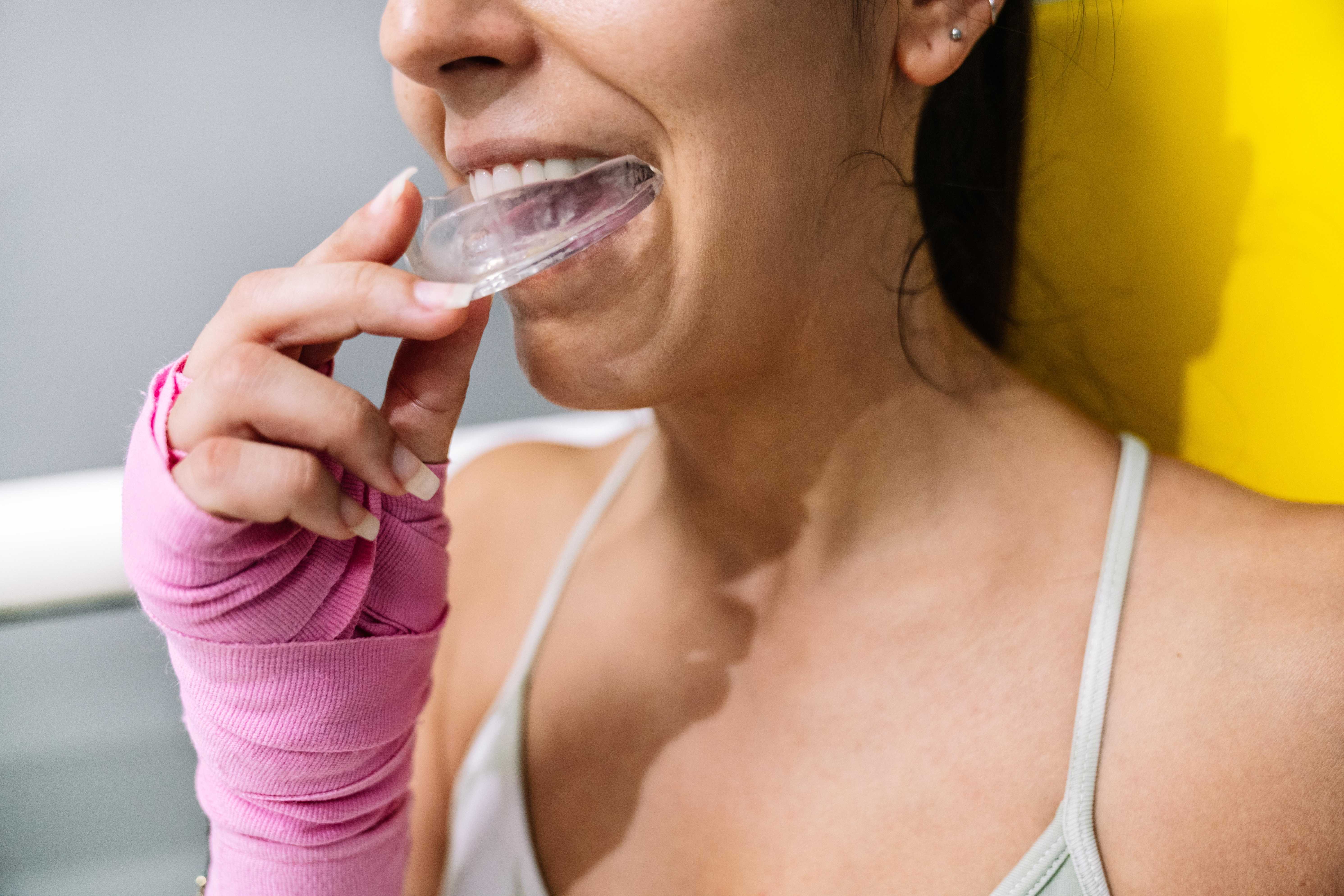 female athlete putting on mouth guards