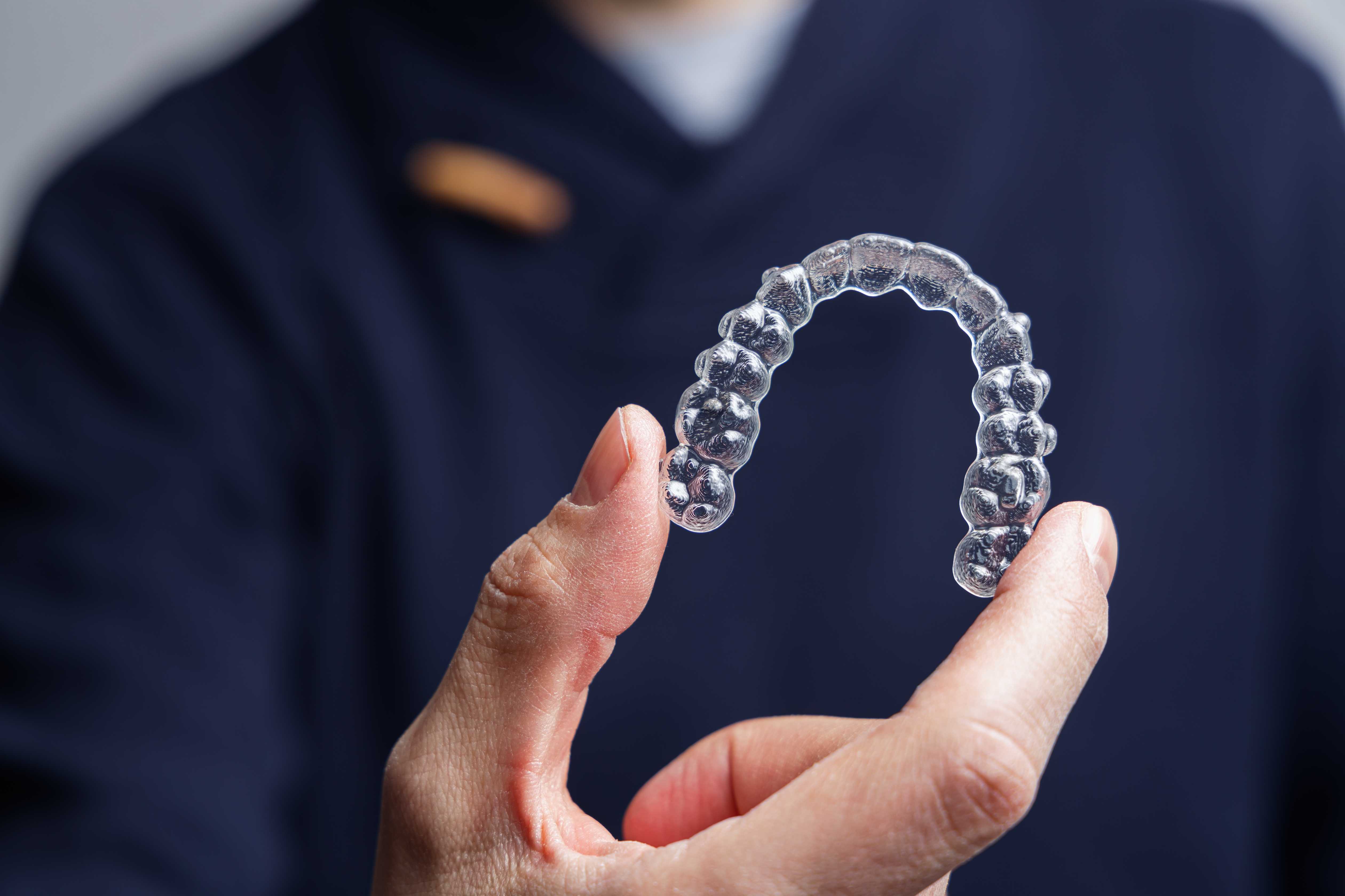 man holding clear aligners