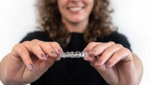 Caucasian young woman showing invisible silicone aligner for dental correction