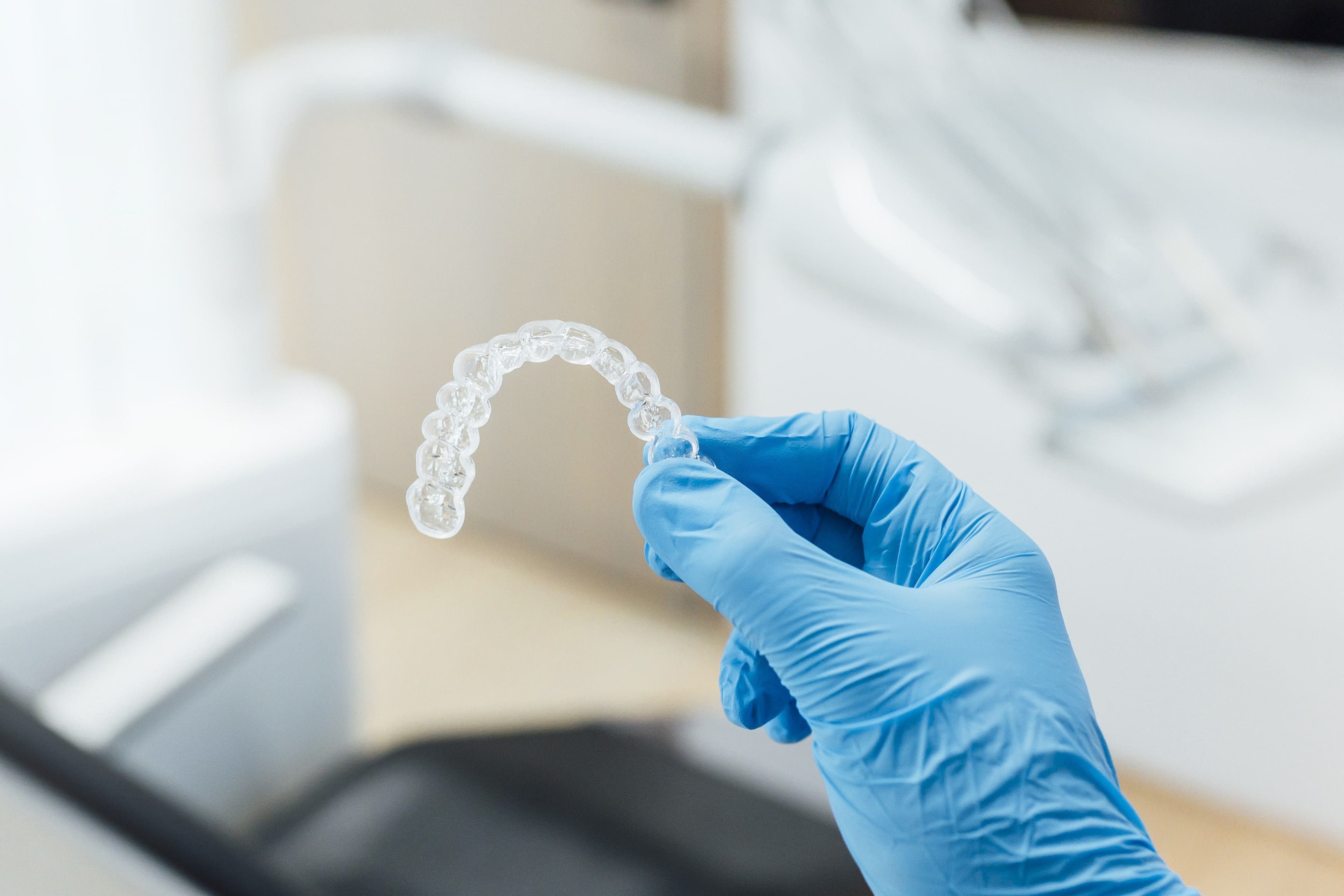 hand holding a clear dental retainer