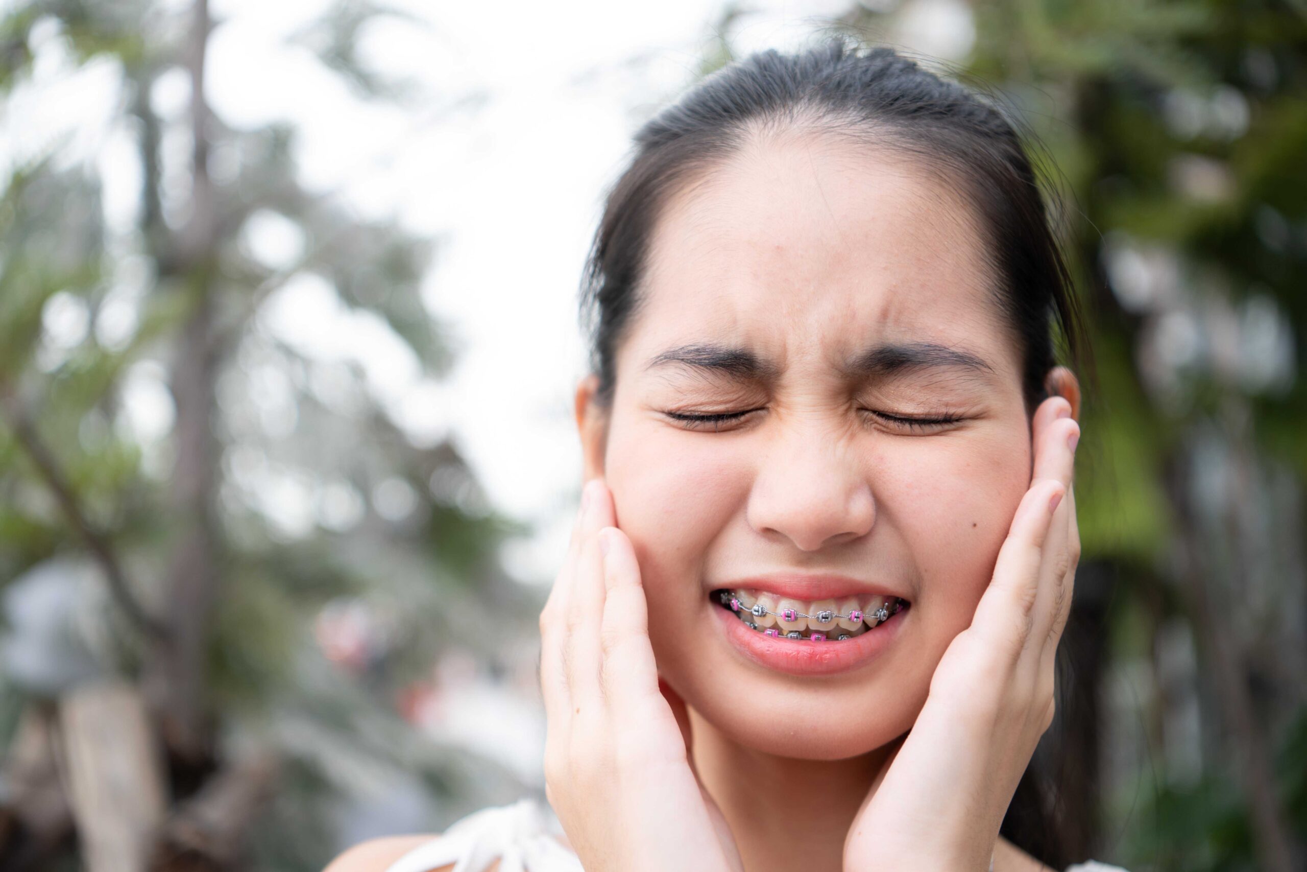 young woman with braces feeling soreness