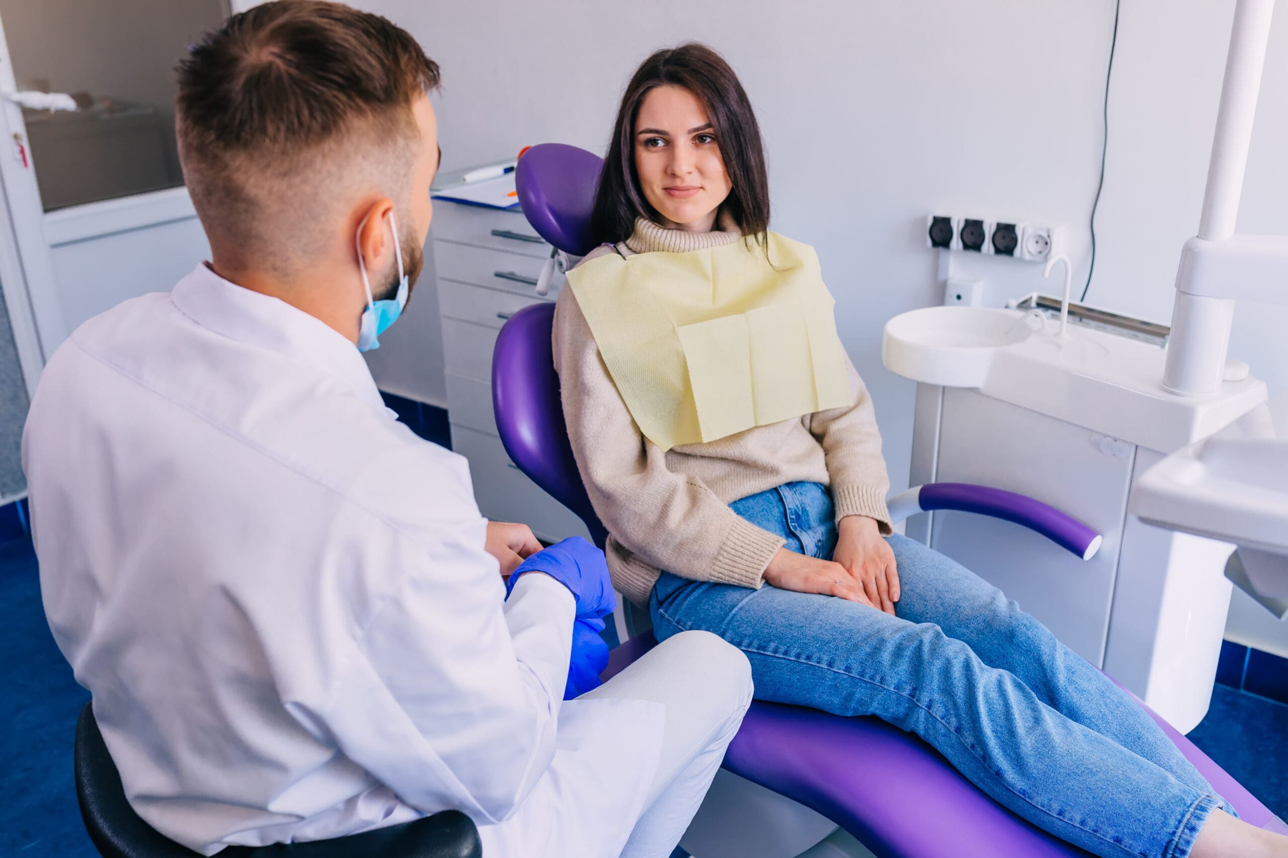 beautiful girl sitting in a chair and listening to an orthodontist. consultation with a dentist. visit.